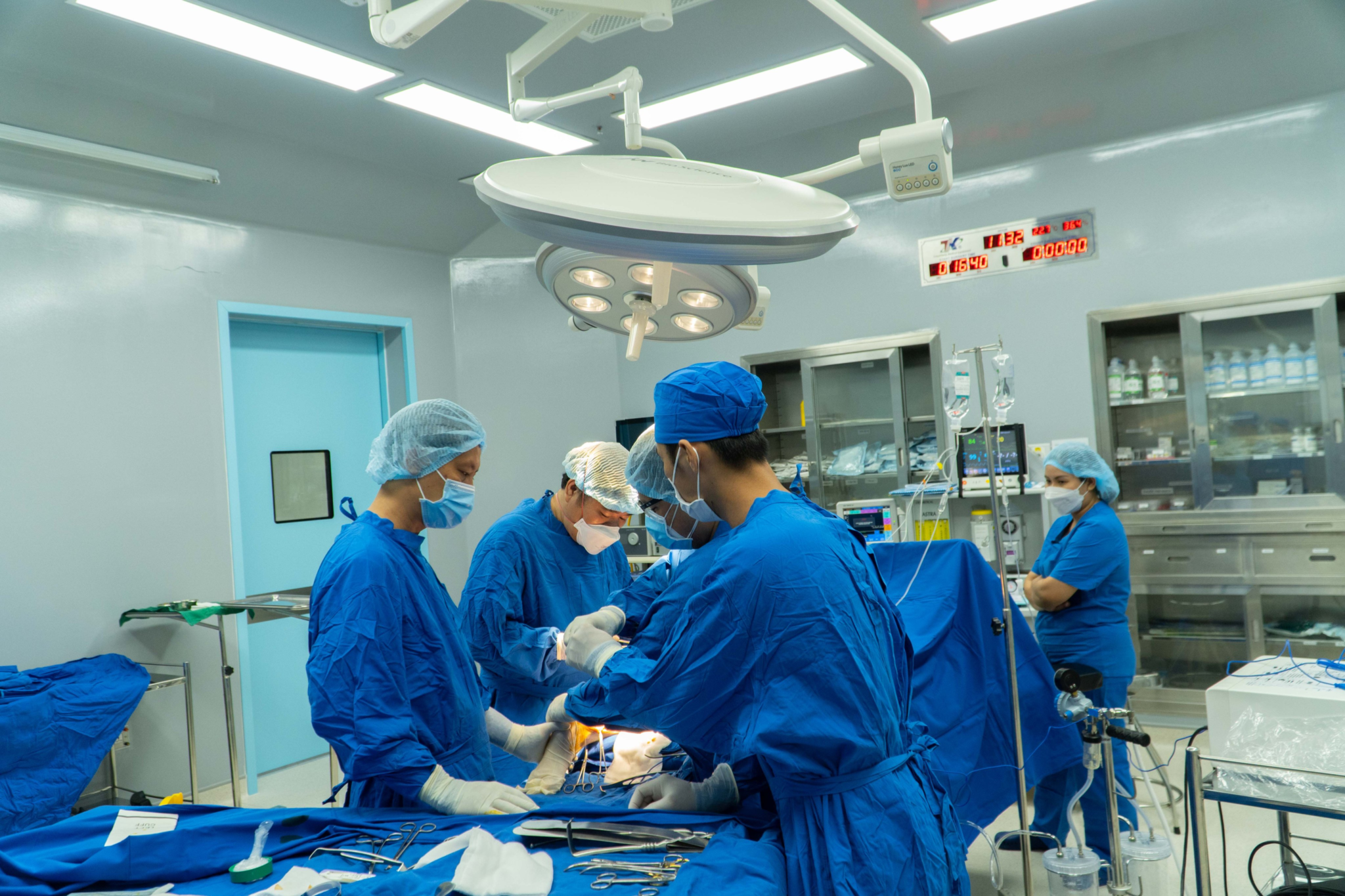 A group of surgeons performing surgery Description automatically generated with low confidence