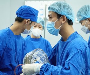 A group of surgeons performing surgery Description automatically generated with medium confidence